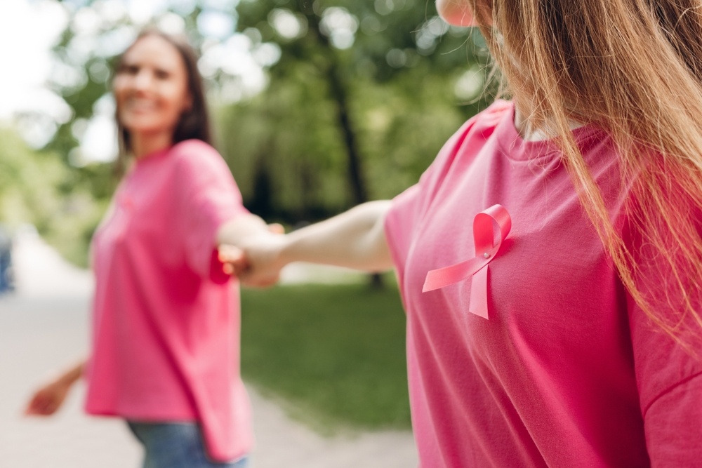 Two,Women,Wearing,Pink,T-shirts,With,Pink,Ribbons,Are,Holding