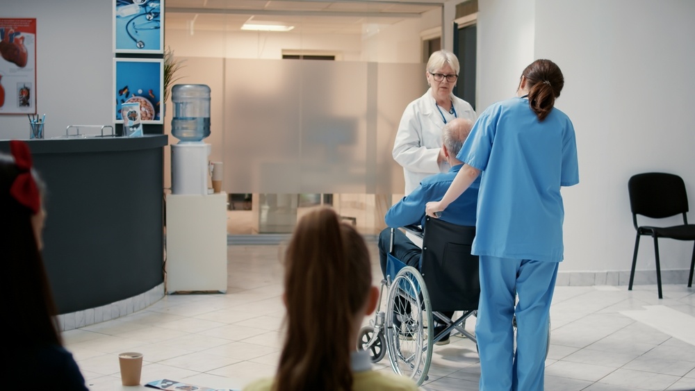 Senior,Physician,Talking,To,Retired,Man,With,Disability,At,Hospital