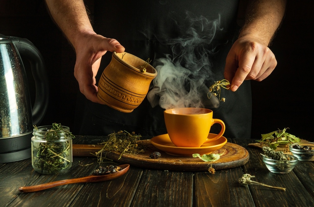 The,Cook,Prepares,Medicinal,Herbal,Tea,On,The,Kitchen,Table. votana me ofeli gia tin ygeia